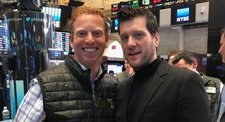 two men standing together and smiling